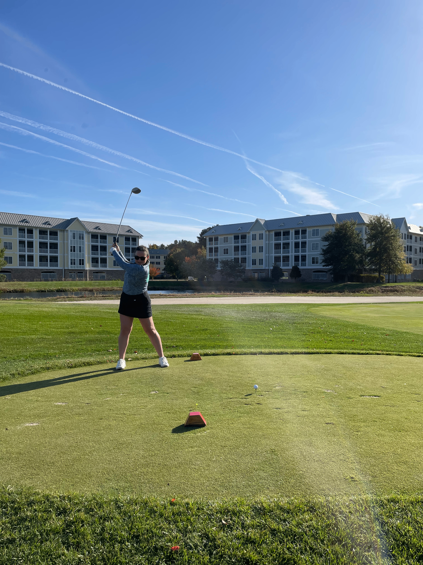 Student teeing off on a sunny day