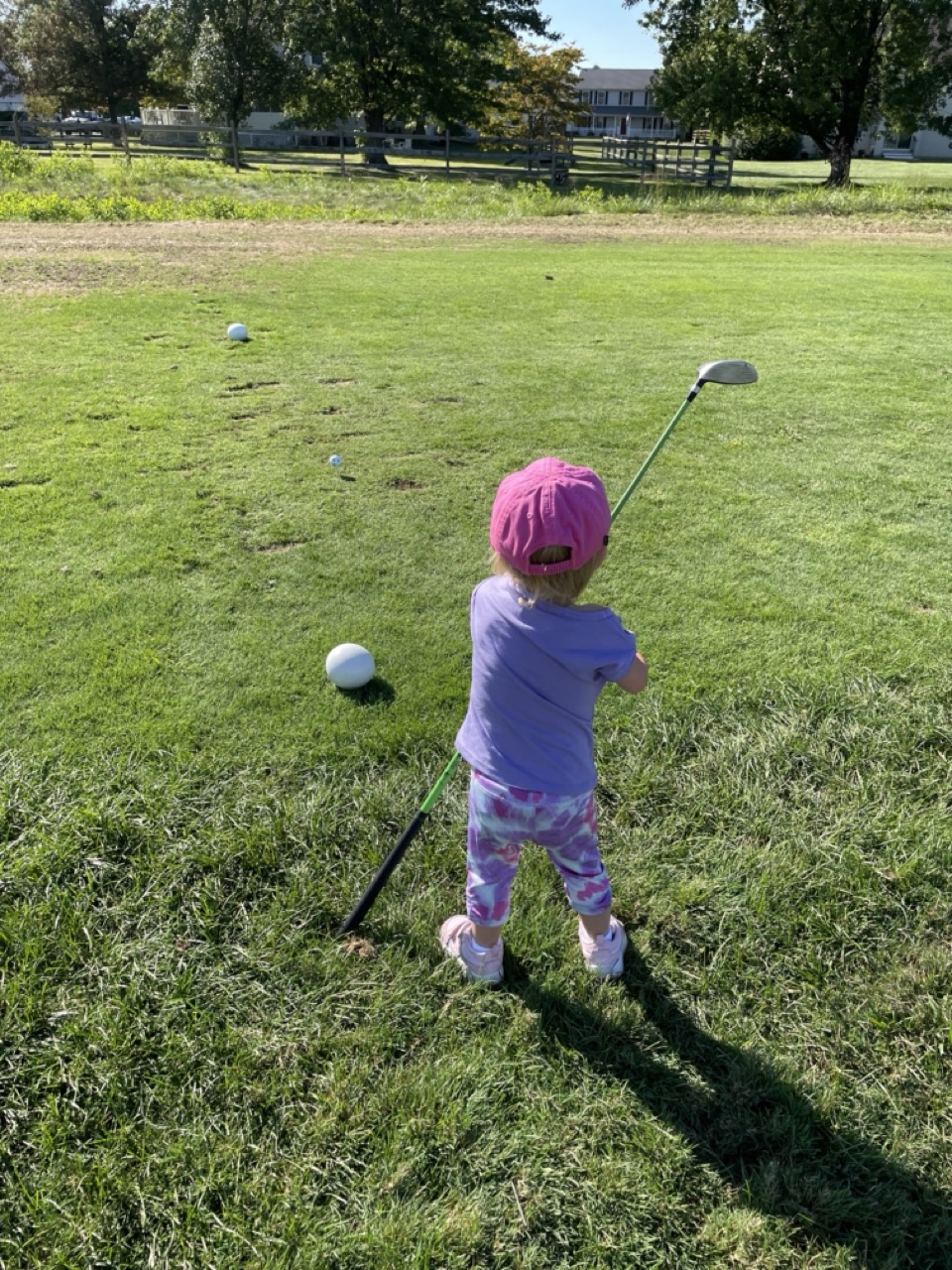 Young junior golfer taking a swing on the grass