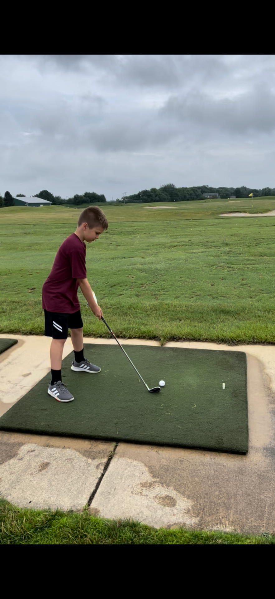 Junior golfer addressing the ball at the driving range